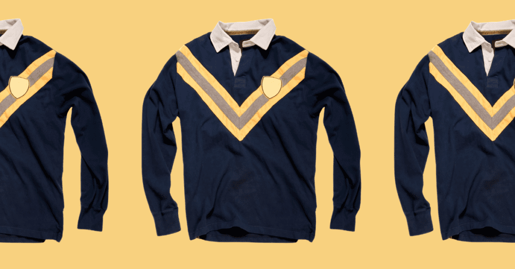 Drei identische langärmelige marineblaue Rugby-Shirts mit weißem Kragen und gelben Chevron-Streifen, die von einem Trikotdesigner entworfen wurden, sind vor einem einfarbigen beigen Hintergrund zu sehen.