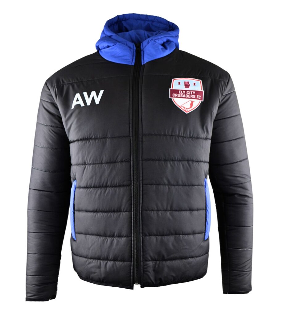 A black puffer jacket with blue lining, front zip, blue-trimmed pockets, initials AW on the left chest, and a red and white Ely City Crusaders FC badge on the right chest.