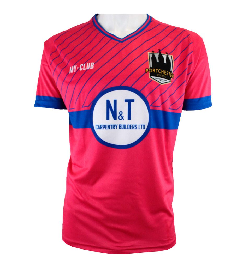 A pink football shirt with blue diagonal stripes, blue collar and sleeve cuffs, and a blue horizontal band. It features a PORTCHESTER club crest, MY-CLUB text, and a large N&T Carpentry Builders LTD sponsor logo.