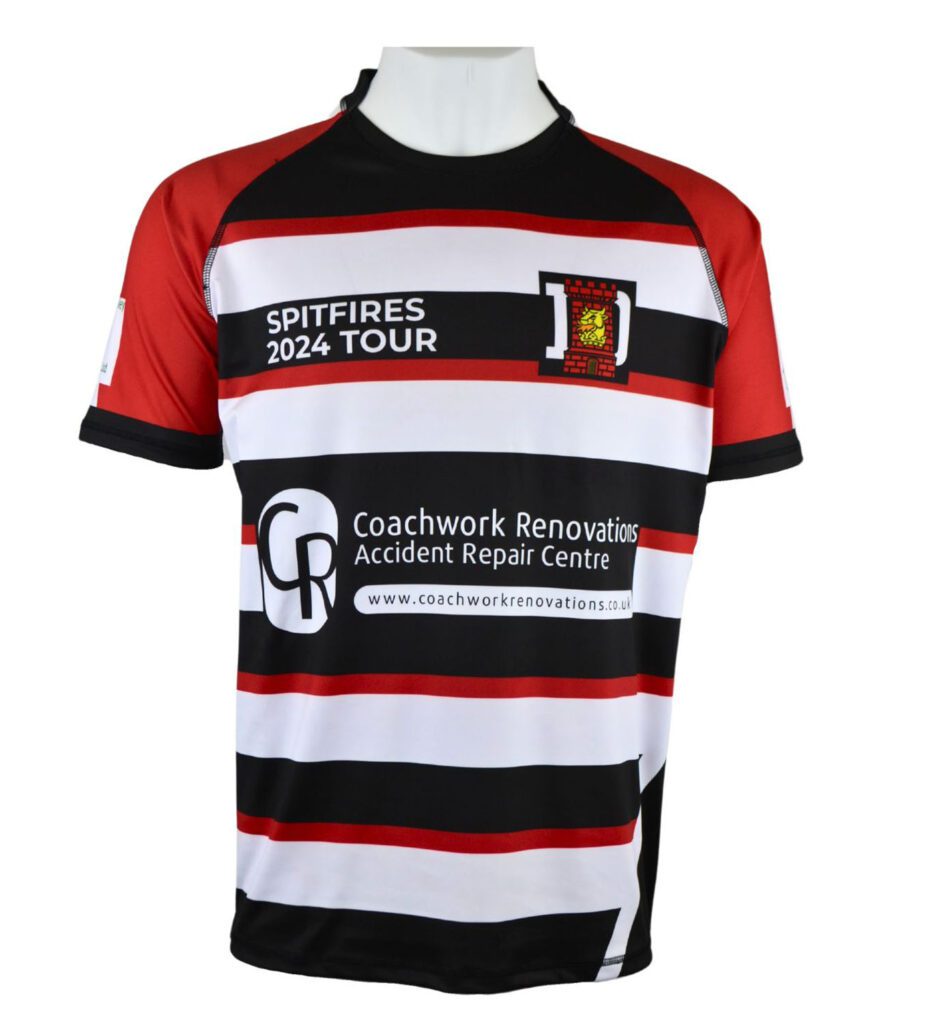 A short-sleeved rugby shirt with red, black, and white horizontal stripes, featuring SPITFIRES 2024 TOUR text and the Coachwork Renovations logo on the front, displayed on a mannequin torso.