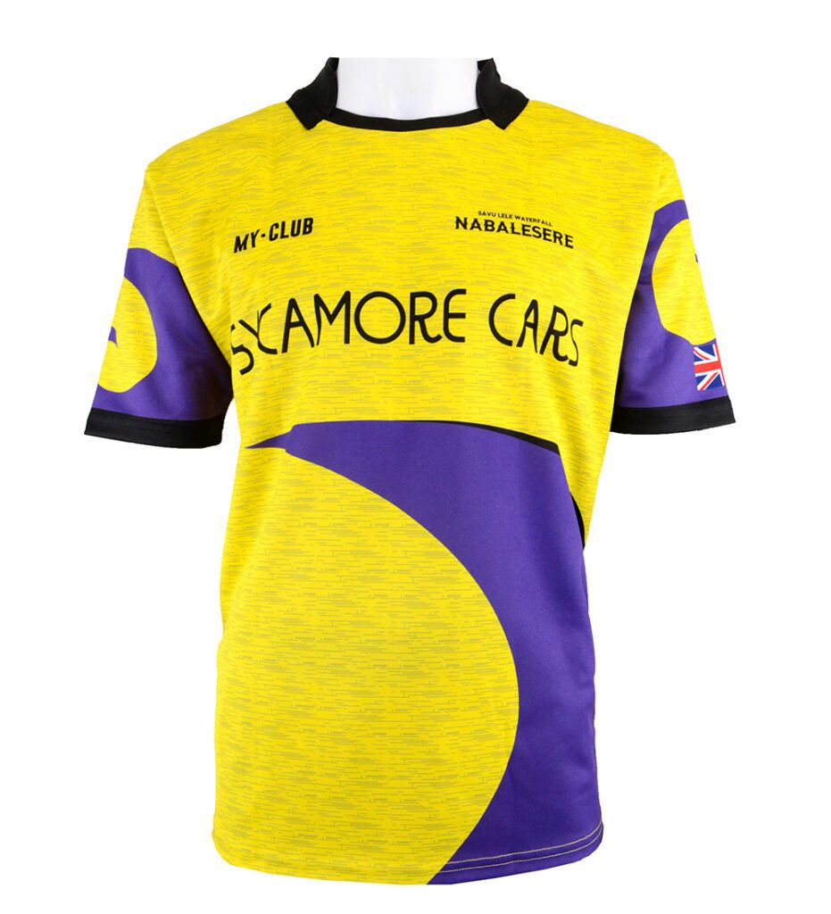A yellow and purple sports jersey with black collar and cuffs, featuring the text “SYACAMORE CARS,” “MY-CLUB,” NABALESERE, and a small UK flag on the sleeve. The design has curved purple shapes.