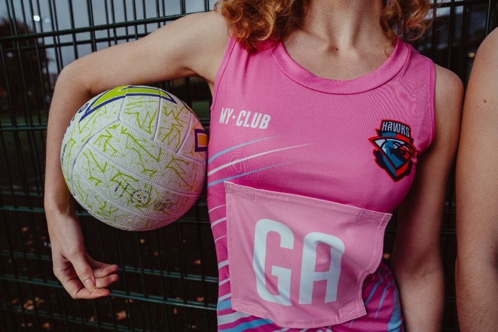 Eine Nahaufnahme von jemandem, der ein von My Club entworfenes Netzballkleid trägt