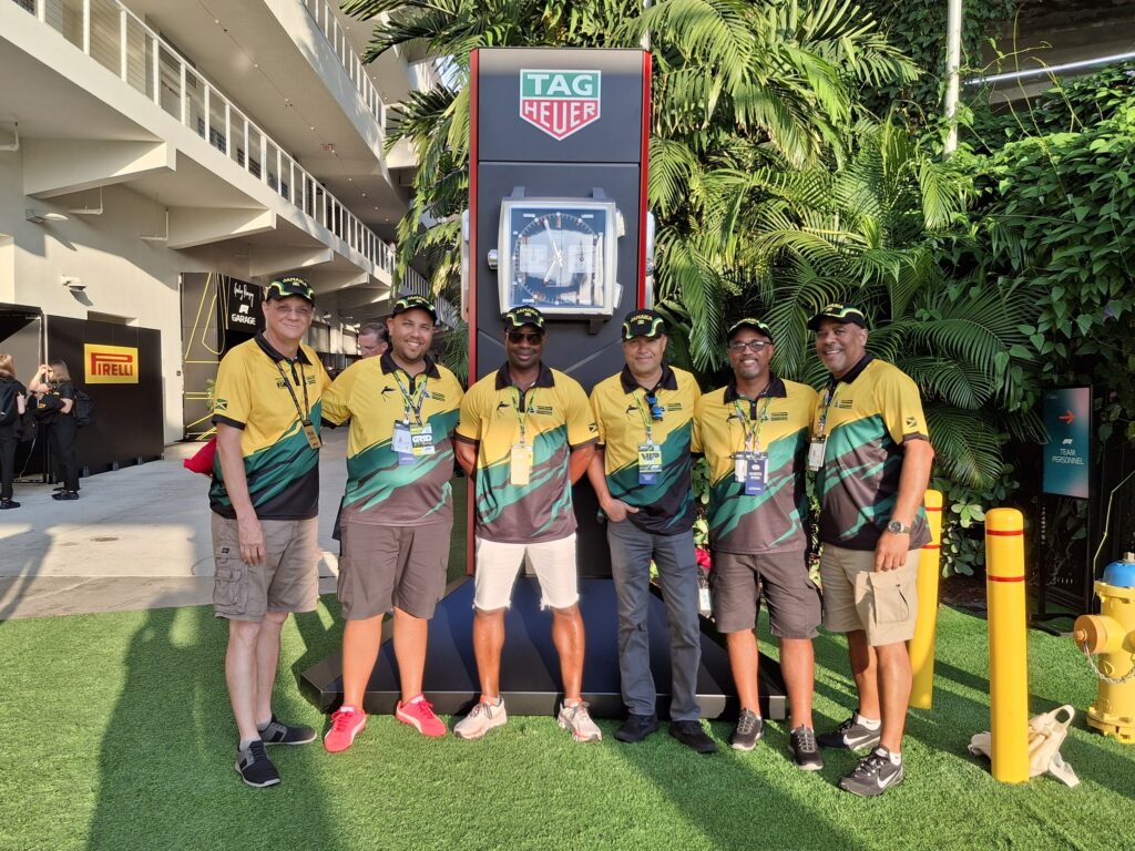 Sechs Mitarbeiter von SG Consulting in einheitlichen Polohemden mit Firmenlogo posieren gemeinsam beim Formel-1-Grand-Prix von Miami.