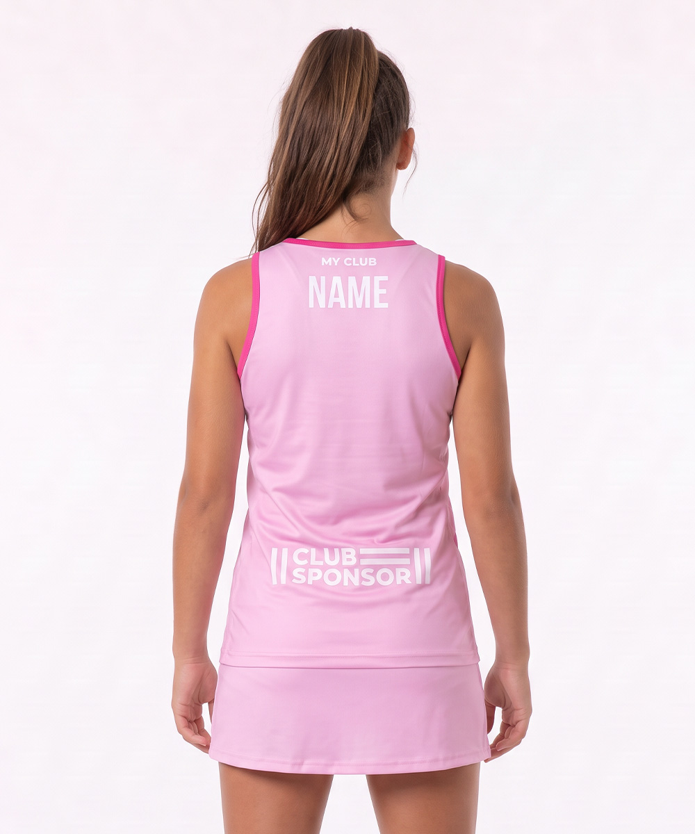 Una donna è raffigurata di spalle, indossa una tuta sportiva rosa simile a una pettorina da netball, con la scritta “MY CLUB NAME” nella parte superiore della schiena e “CLUB SPONSOR” sotto, entrambe in bianco. Lo sfondo è semplice e di colore chiaro.