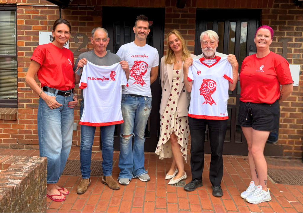 My Club Group team and Clockwork charity trustees outside the Oxted office, holding up the new Clockwork-branded sublimated shirts