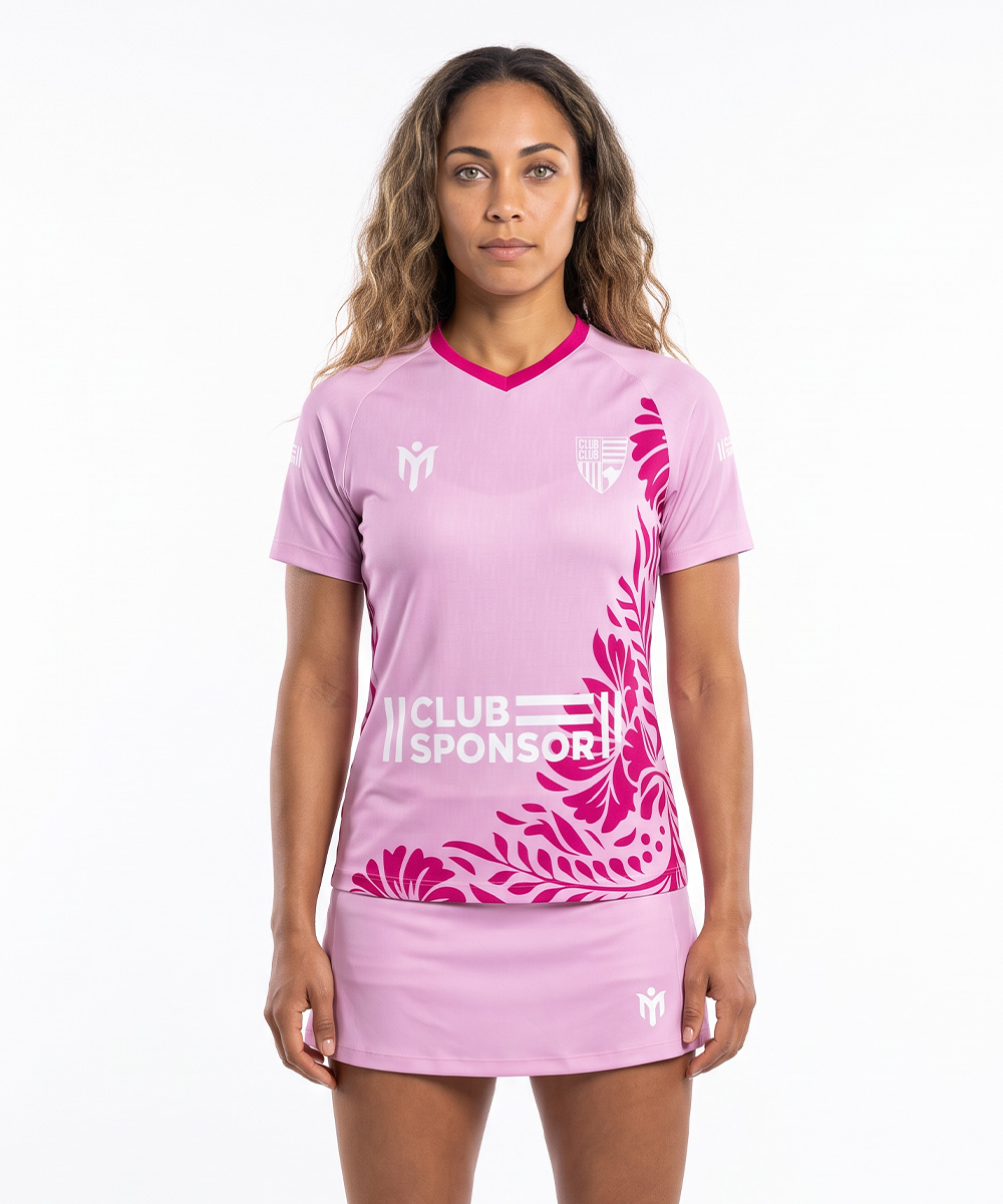 Eine Frau, die ein rosa Sporttrikot mit Blumenmuster und der Aufschrift „CLUB SPONSOR“ trägt, dazu passend einen maßgeschneiderten Tennisrock.