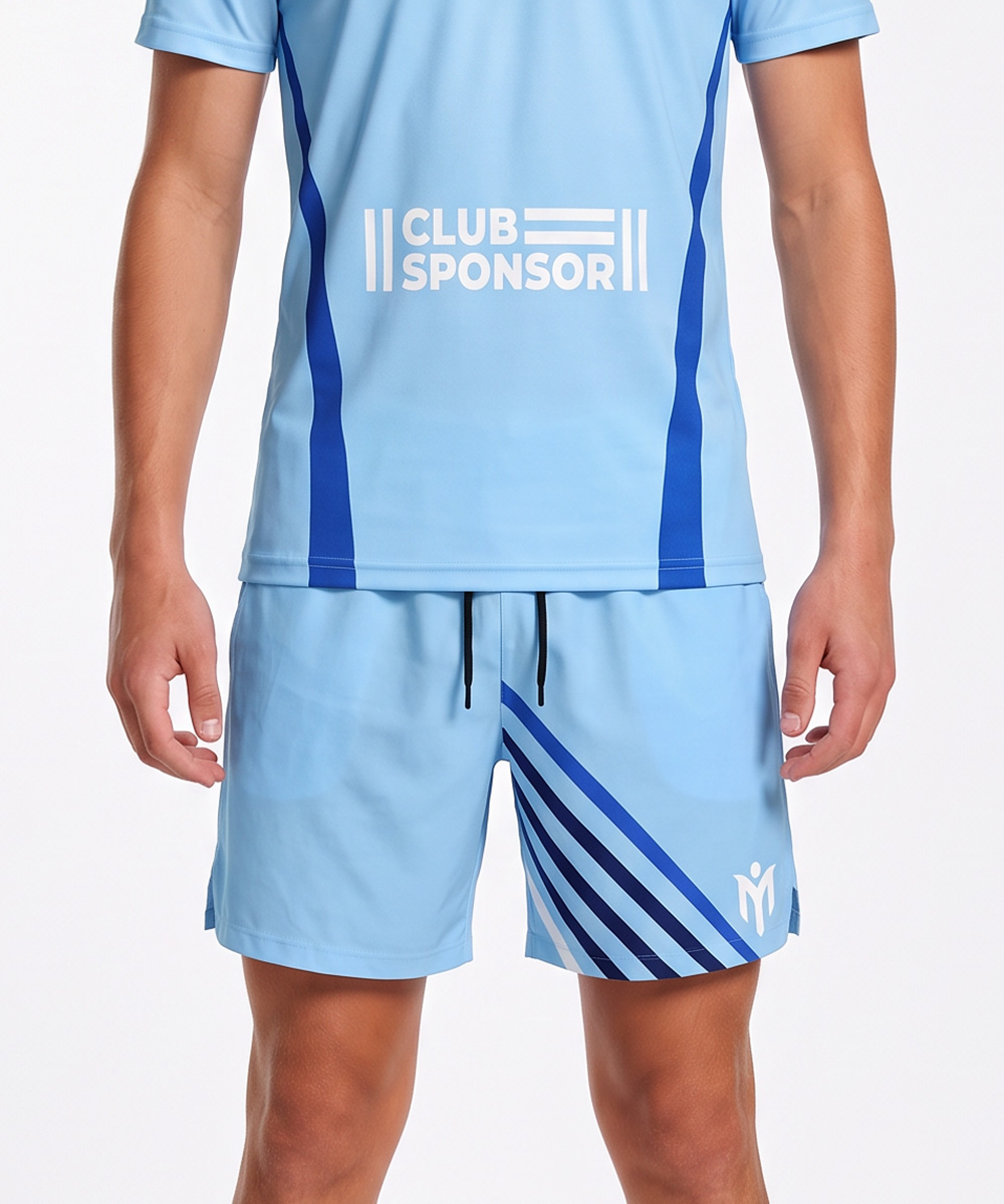 Eine Person, die ein hellblaues Sportshirt mit der Aufschrift „CLUB SPONSOR“ und maßgeschneiderte Tennisshorts mit dunkelblauen diagonalen Streifen und einem weißen Logo am Bein trägt.