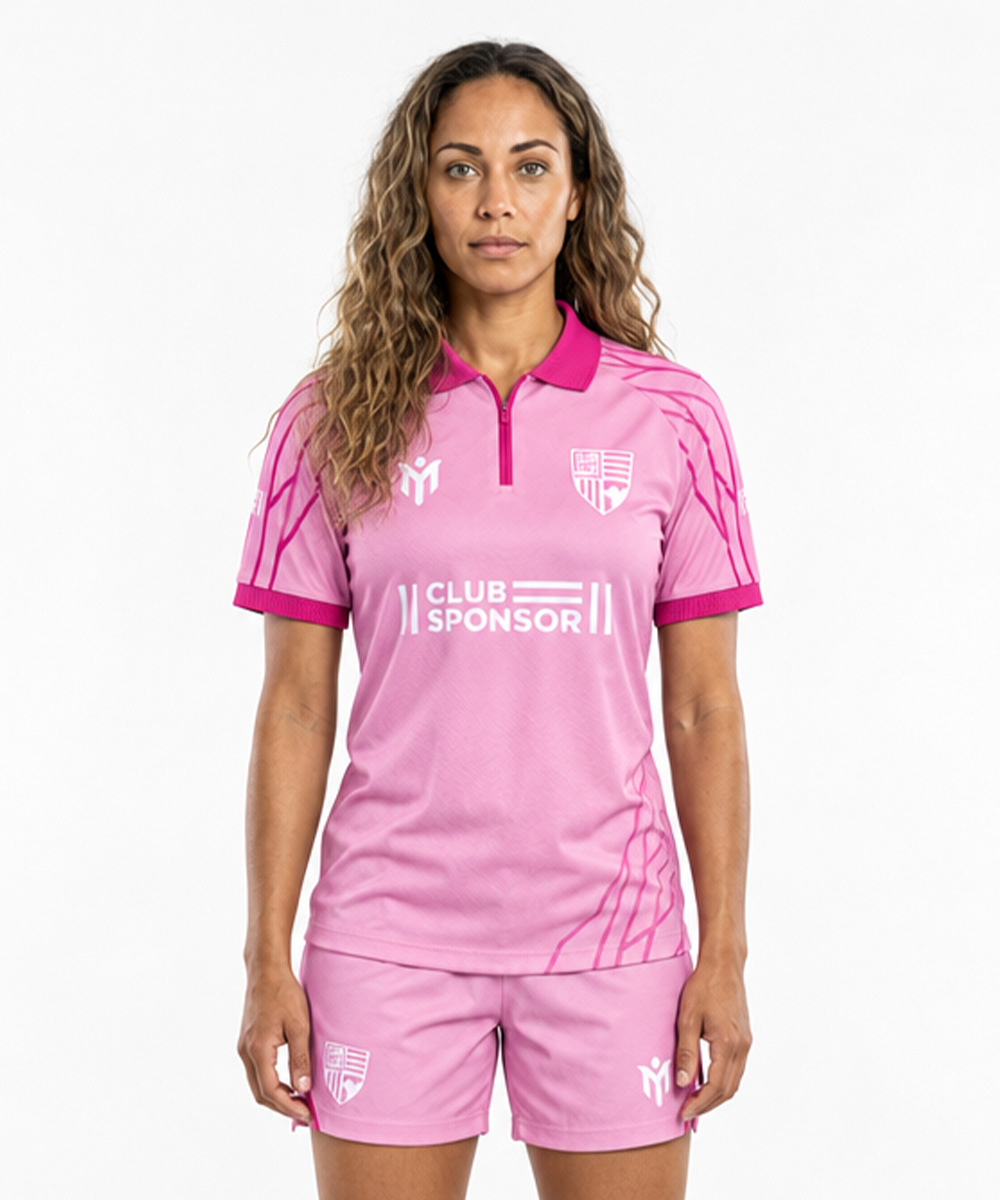 Une femme portant un maillot de football rose de style polo de tennis haut de gamme, doté d'un col polo, sur lequel figurent l'inscription « CLUB SPONSOR » ainsi que les logos de l'équipe, tant sur le maillot que sur le short.
