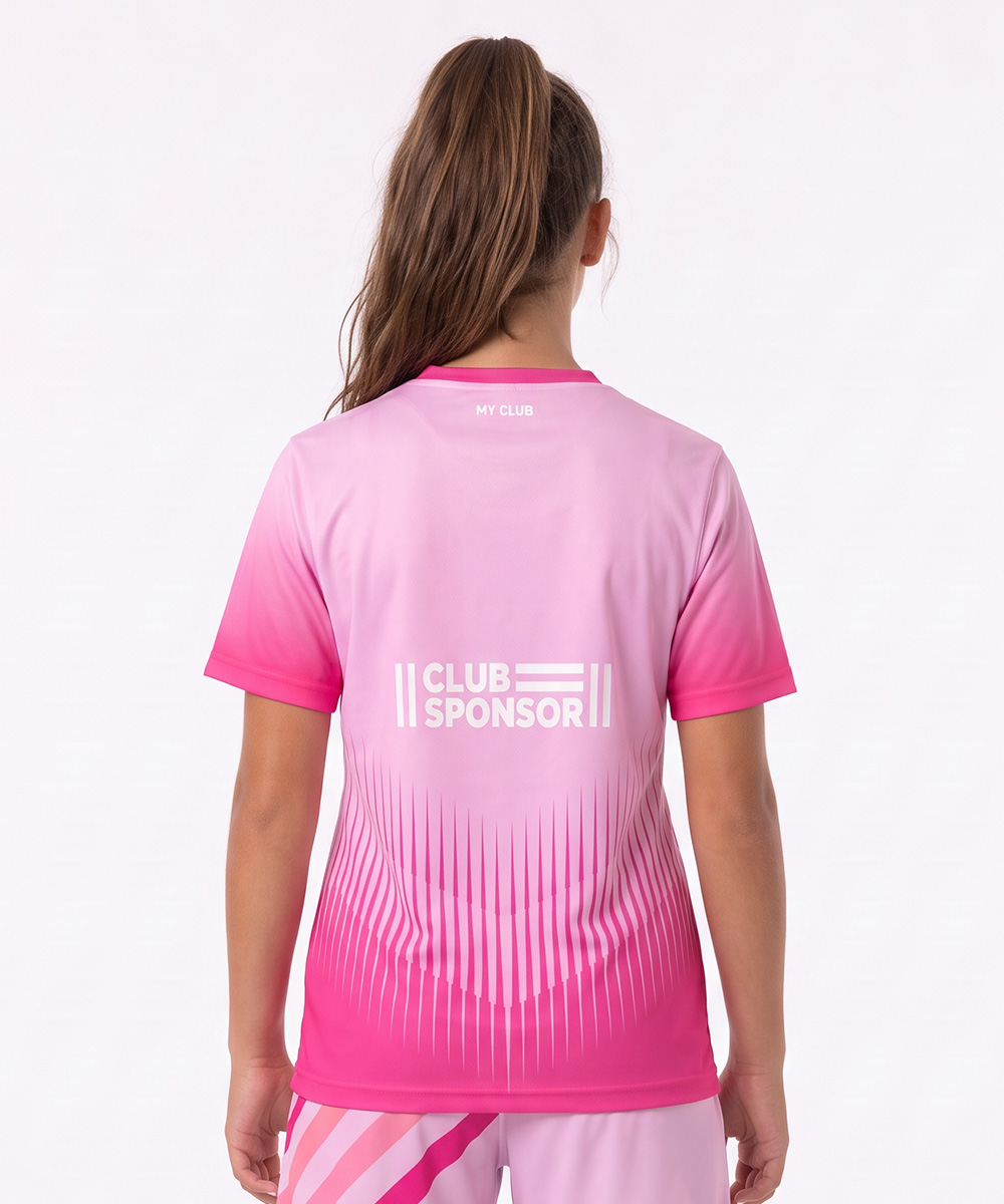 Una ragazza dai lunghi capelli castani raccolti in una coda di cavallo indossa una maglietta e dei pantaloncini da atletica rosa personalizzati ed è in piedi di spalle alla fotocamera. Sulla divisa si legge “MY CLUB” sul collo e “CLUB SPONSOR” con delle linee sotto.