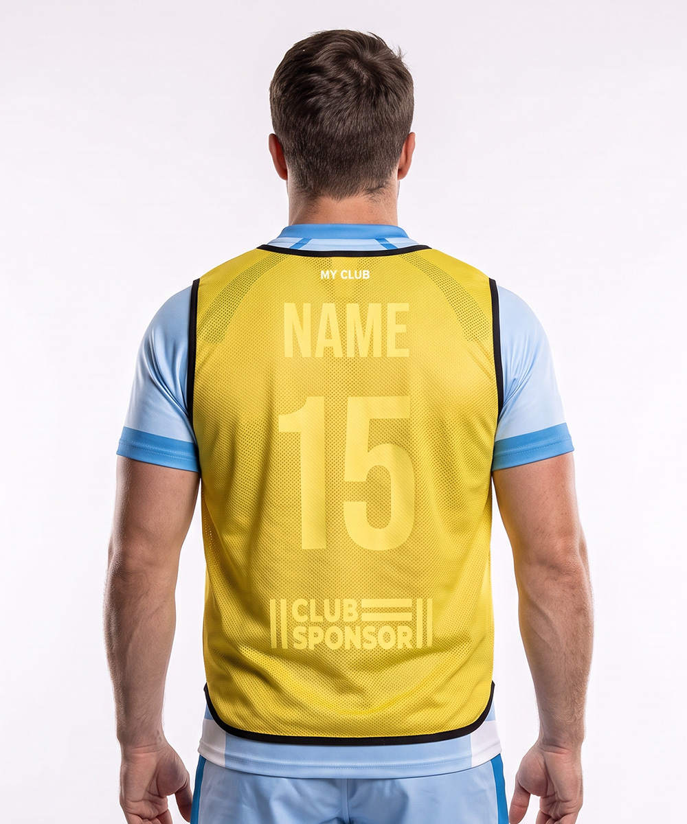 Eine Person, von hinten gesehen, die eine gelbe, individuell gestaltete Trainingsweste über einem hellblauen Sportshirt trägt, auf dem die Aufschriften „MY CLUB“, „NAME“, „15“ und „CLUB SPONSOR“ zu sehen sind.