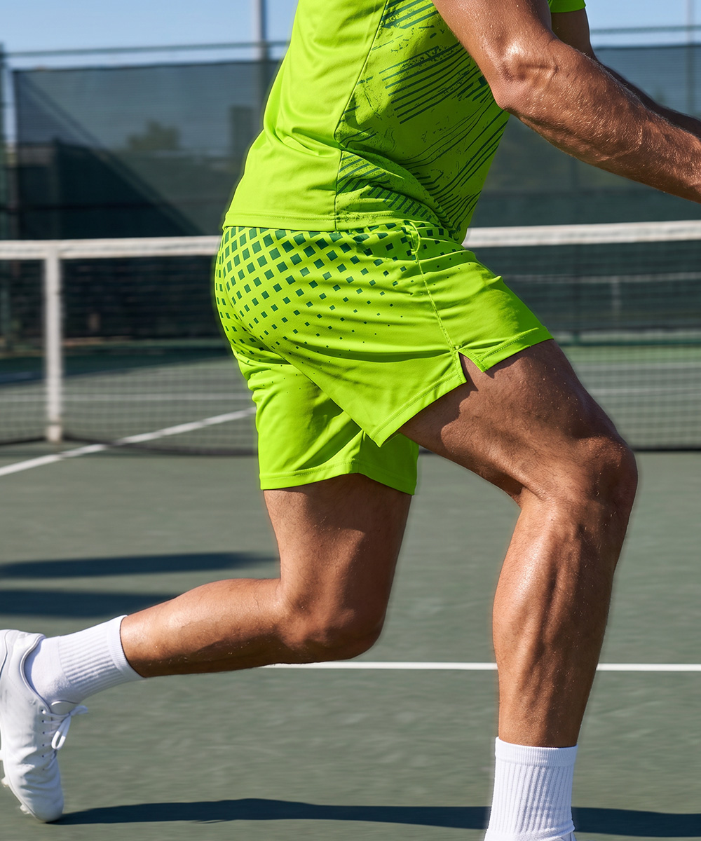 Une personne effectuant une fente sur un court de tennis, vêtue d'un short de tennis recyclé sur mesure et d'un t-shirt assorti.